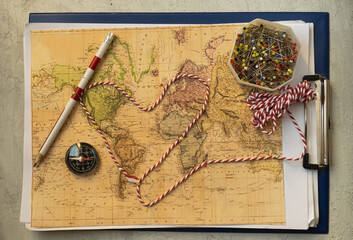 Make travel plan with blurry,old world map,pins, rope and compass, Selective focus on some areas 