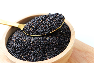 Black sesame seeds in wooden bowl.