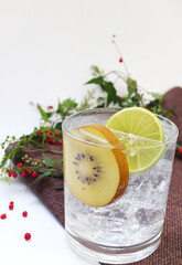 Summer cocktail with kiwi, lime and ice. Kiwi soda in a glass.