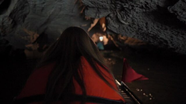 Slowmotion shot of a young woman on a boat having a river trip through rocks in Ninh Binh, a tourist destination in northern Vietnam. Travel to Vietnam concept