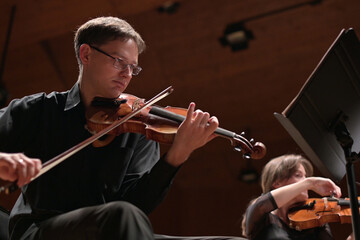 Violinist in black clothes plays the violin to the accompaniment