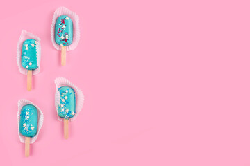 Blue mint ice cream popsicles on pastel pink background. Tasty and refreshing icecream on sticks. Minimal summer concept. Flat lay, free copyspace for text