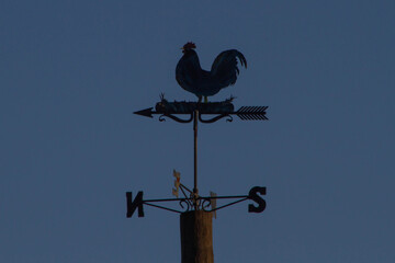 Weather Vane Rooster,Wind Vane or weathercock with dusk background,local at Bracciano port,Italy.