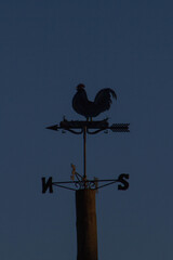 Weather Vane Rooster,Wind Vane or weathercock with dusk background,local at Bracciano port,Italy.