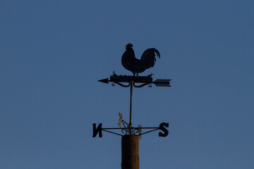 Weather Vane Rooster,Wind Vane or weathercock with dusk background,local at Bracciano port,Italy.