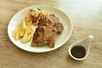grilled pork neck steak with french fries and salad dressing mayonnaise on plate dipping spicy sauce