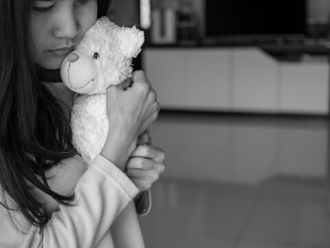 Asian woman hug deddy bear with loneliness. black and white image. broken heart concept.