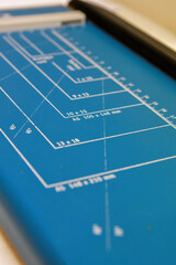 A blue paper cutter showing graduated paper sizes.