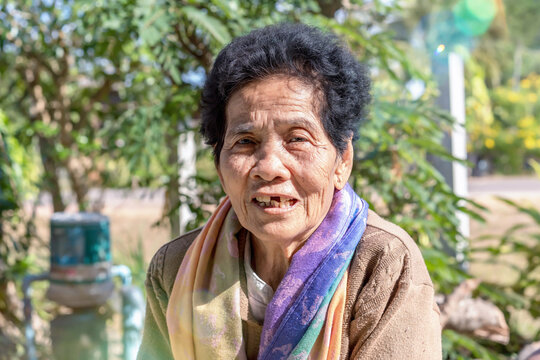 Close-up of old Asian woman face with wrinkles elderly senior
smiling happiness with a few broken teeth, looking at the camera. Senior woman healthy has positive thoughts on life. Healthcare concept