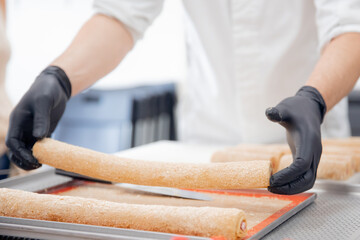 Chef hand in patisserie restaurant prepares cakes and decorates with chocolate icing