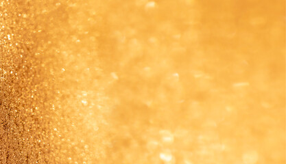 Beautiful shiny sparkling abstract holiday bokeh photo background. Gold color glitter banner with empty copyspace