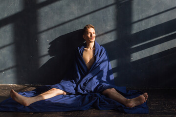 Man in blanket sitting on the floor