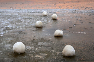 Fototapeta na wymiar Frozen ice balls on the beach in Jastarnia during winter. Hel Peninsula, Poland
