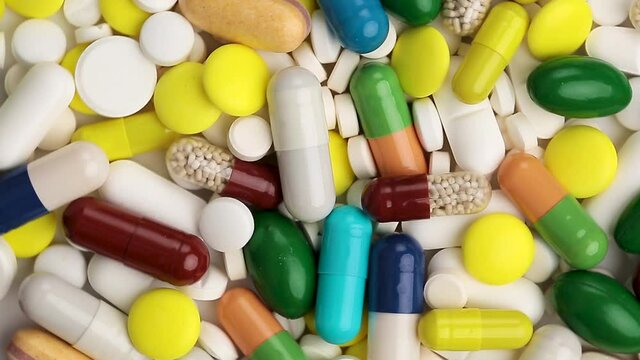 Various medicinal pills and capsules for health as background with circular rotation. Food supplements and vitamins for heart health and antivirals, Pharmaceuticals.