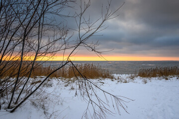Snow covered beach at sunset, winter landscape in Jastarnia on the coast of the Hel Peninsula. Poland