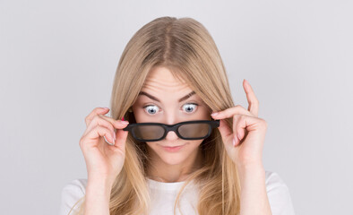 Young woman with glasses is very surprised looking down and lowering her glasses. Surprise and shopping concept on white background. © Studio Nova