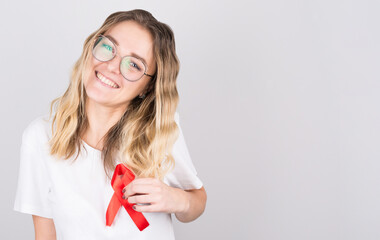 Young woman holding red gold ribbon awareness symbol for endometriosis, suicide prevention, sarcoma bone cancer, bladder cancer, liver cancer and childhood cancer concept.