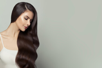 Fashion portrait of nice model woman with long healthy hair on white background, beautiful face...