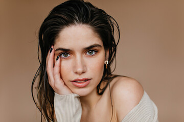 Close-up portrait of carefree brunette woman. Serious european lady posing on brown background.