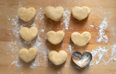 The heart cookies cutter and the doughs on the wooden cutting board. Valentine's day baking...