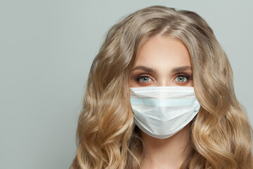 Happy young woman in protective medical mask on white background