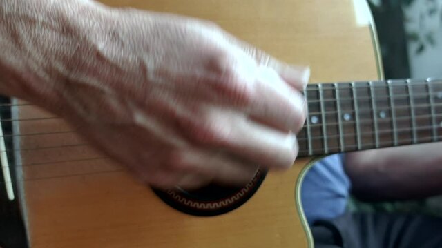 An acoustic guitar being strummed