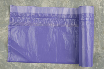 neatly stacked purple garbage bags on a concrete background. Place for the ad label.. Top view. Close-up