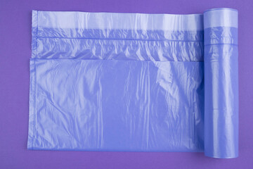 neatly folded purple garbage bags on a purple background. Place for the ad label.. Top view. Close-up