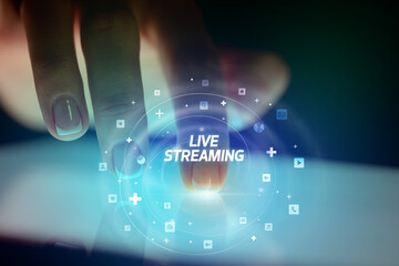 Finger touching tablet with social media icons and LIVE STREAMING