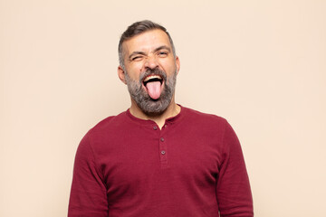 adult handsome man with cheerful, carefree, rebellious attitude, joking and sticking tongue out,...