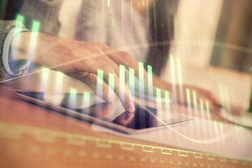Double exposure of forex graph drawing and man and woman working together holding and using a mobile device. Trade concept.