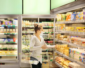 supermarket shopping, face mask and gloves,Woman choosing a dairy products at supermarket