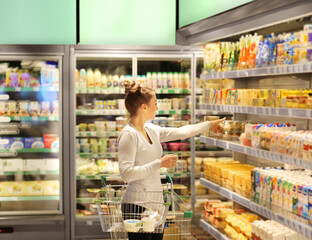 Woman choosing a dairy products at supermarket.