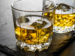 Whisky on the rocks on black slate