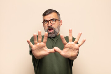 adult handsome man feeling terrified, backing off and screaming in horror and panic, reacting to a...