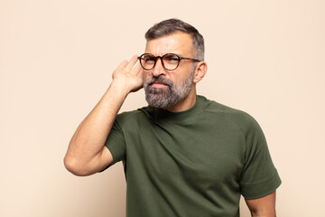 adult handsome man looking serious and curious, listening, trying to hear a secret conversation or...