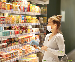 supermarket shopping, face mask and gloves,Woman choosing a dairy products at supermarket