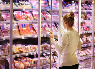 Woman choosing a dairy products at supermarket.