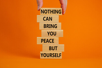 Concept of building success foundation. Businessman hand. Wooden blocks with words nothing can bring you peace but yourself. Beautiful orange background, copy space. Business and motivational concept.