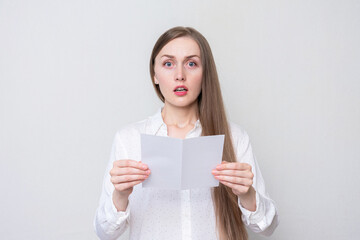 Naklejka premium Portrait of a shocked woman reading a letter, white background