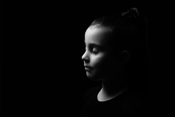Closeup portrait of happy little girl isolated on black background