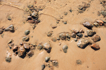Background of transparent sea water and bottom with rocks, close-up, top view