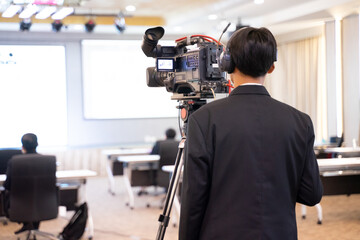 The cameraman setting up the camera for the upcoming conference