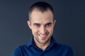 Obraz premium Sly young man standing in front of a black background, portrait, horizontal