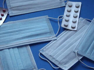 light blue medical masks and colorful covid 19 pills. High quality photo