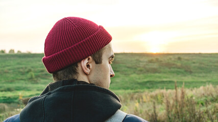 Lonely man on the background of a beautiful landscape, the guy looks into the distance, close-up, rear view