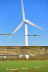 Blurry large windmill against the blue sky.