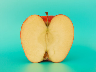 Sliced fresh apple on a turquoise background.