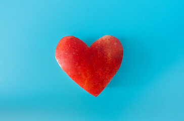 Red heart from an apple on a blue background.