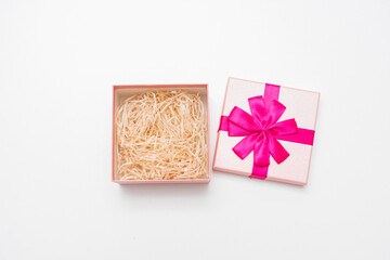 Open pink gift for New year, white background, closeup, copy space, top view